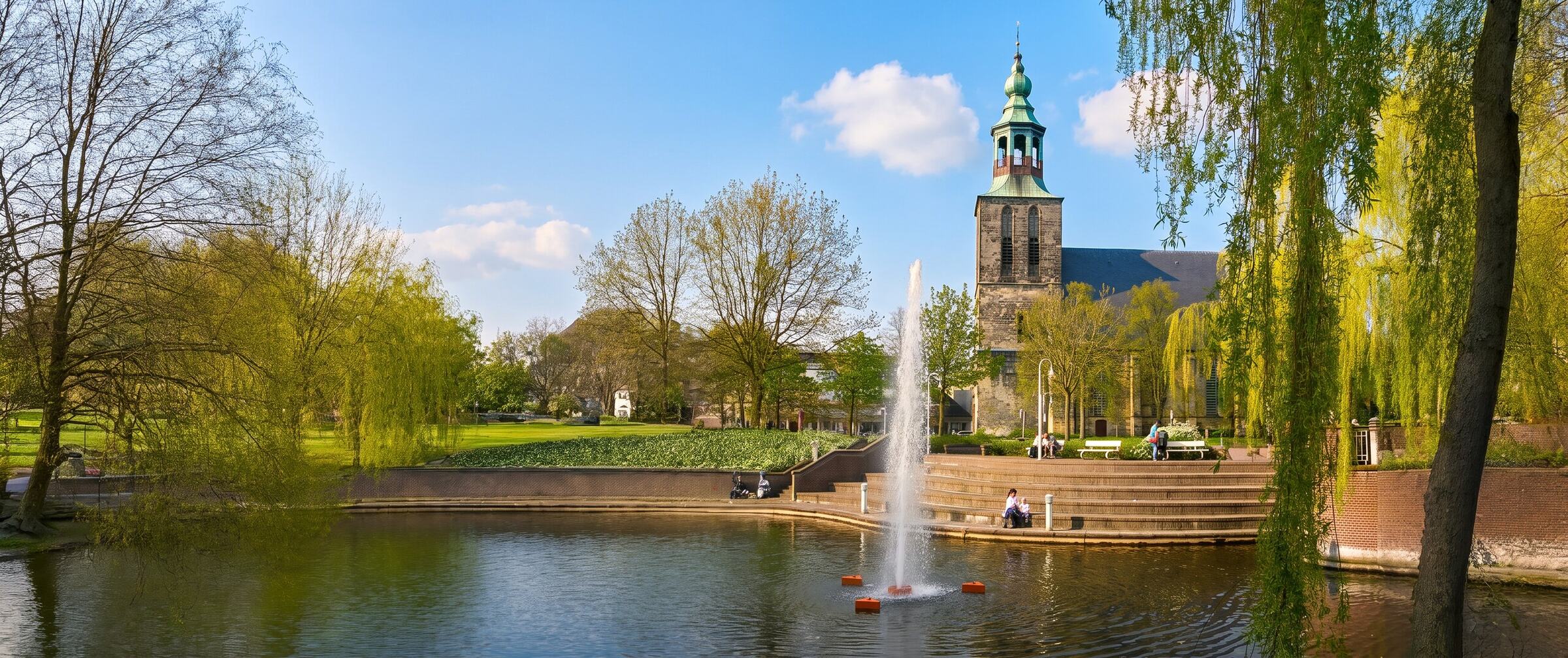 Die Alte Kirche am Markt in Nordhorn, davor der Springbrunnen im Wasserbecken